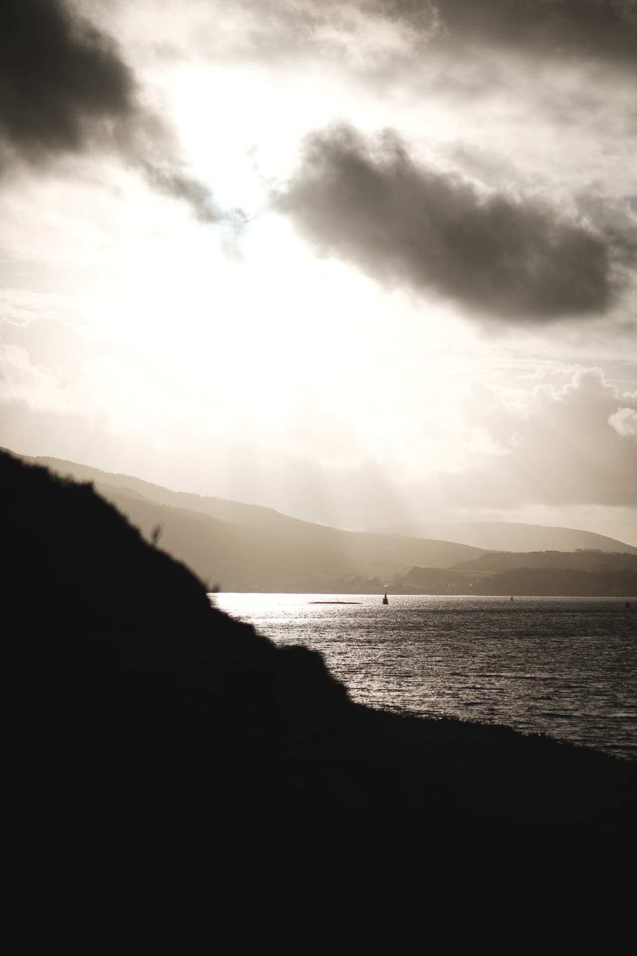 Sunlight breaking through clouds over Davaar's coast